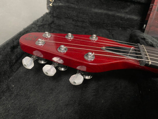Close-up of red RS guitar headstock with six tuning pegs and white tuning knobs on black plush guitar case lining