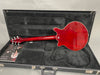 Back view of red electric guitar inside black hard case with plush interior and Brian May red special booklet