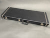 Black rectangular guitar hard case with metal latches and handle on gray background