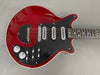 Vintage red electric guitar with black pickguard and three single-coil pickups, close-up on body and fretboard