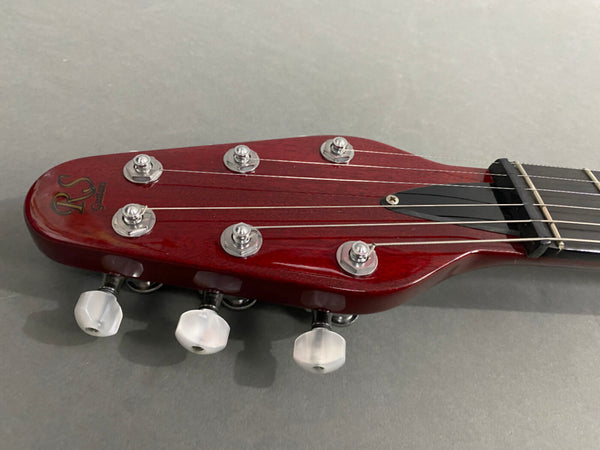 Close-up of RS Guitars red mahogany headstock with silver tuning pegs and white tuning keys on acoustic guitar