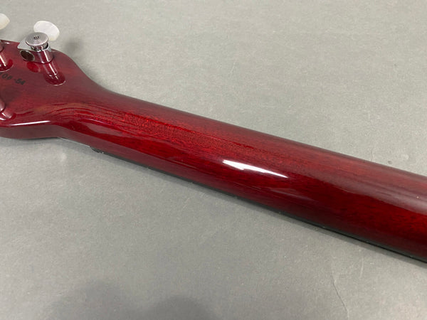 Close-up of glossy red finished guitar neck and headstock with tuning pegs on grey background