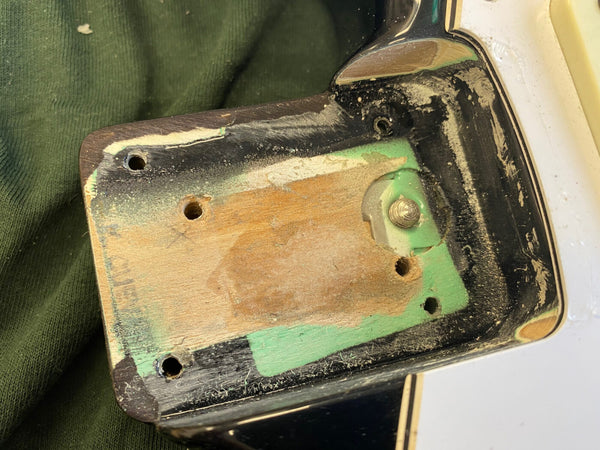 Close-up of vintage electric guitar neck pocket with worn paint and screw holes on weathered wood body section at Coffee House Guitars