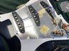 Close-up of electric guitar pickguard showing three single-coil pickups with wiring and potentiometers for guitar electronics repair or upgrade