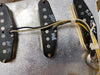Close-up of vintage Fender Stratocaster single-coil pickups with wiring and metal baseplate visible.