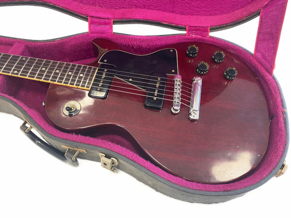 Vintage electric guitar with rosewood fretboard and dual P90 pickups in open hard case with purple plush lining
