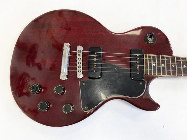 Vintage cherry red electric guitar with black pickguard and dual single-coil pickups on white background