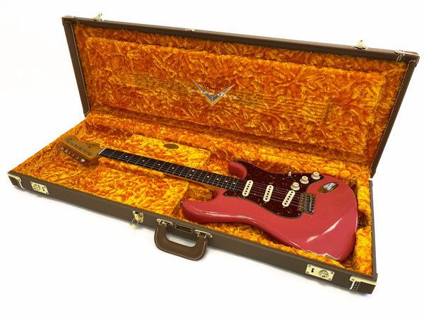 Fender Stratocaster electric guitar in pink finish with tortoiseshell pickguard in open vintage-style hard case with bright orange plush interior lining