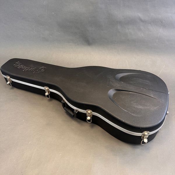 Black hard shell guitar case with metal latches and molded handle for acoustic guitar protection