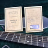 Martin & Co warranty cards for D28L acoustic guitar with handwritten model and serial number, displayed on guitar case interior with guitar fretboard in foreground