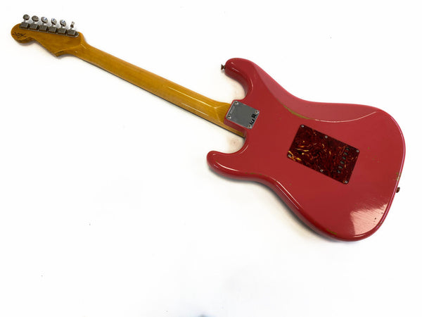 Red electric guitar with maple neck and six tuning pegs, back view showing wear and tortoiseshell backplate, white background.