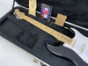 Fender American Series black electric guitar with maple neck and white pickguard inside hard case with tremolo arm and Fender manuals