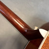 Close-up of mahogany guitar neck heel with glossy finish and cream binding on acoustic guitar body