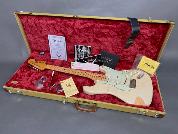 Fender Stratocaster electric guitar with vintage white finish, maple neck, and aged pickguard in tweed hard case with red plush interior, including certificate of authenticity, Fender custom care booklet, tremolo arm, maintenance tools, and original paperwork.