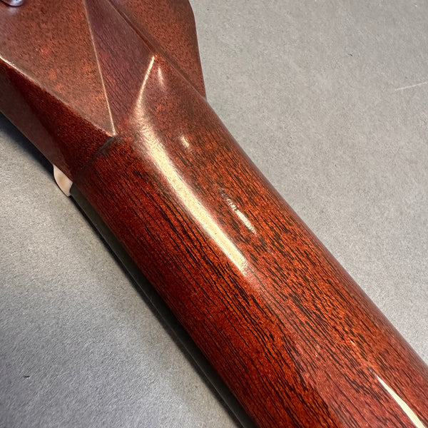 Close-up of the polished mahogany neck heel joint on a Coffee House Guitars acoustic guitar showing wood grain and finish.
