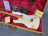 Fender Vintage Stratocaster electric guitar in white with maple neck and aged finish, displayed in a red velvet hard case with original Fender certificate of authenticity, care booklet, tremolo arm, and Fender branded strap and cleaning cloth.