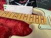 Close-up of Fender Custom Shop guitar maple neck and fretboard with vintage white body, in red plush guitar case with Fender paperwork and custom care booklet in background