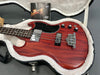 Gibson electric bass guitar in cherry wood finish with chrome hardware, black pickguard, and control knobs inside plush white-lined guitar case with Gibson owner's manual