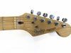 Close-up of Fender Stratocaster guitar headstock with tuning pegs, natural wood finish, and serial number E 453760, made in USA.