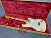 Vintage Fender Stratocaster electric guitar in aged white finish with maple neck and fingerboard, shown inside open tweed hard case lined with plush red velvet interior
