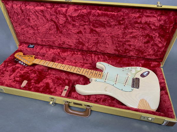 Vintage Fender Stratocaster electric guitar in aged white finish with maple neck and fingerboard, shown inside open tweed hard case lined with plush red velvet interior