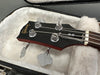 Close-up of Gibson bass guitar headstock with tuning pegs inside plush-lined hard case