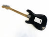 Back view of black Fender Stratocaster electric guitar with maple neck and chrome tuning pegs on white background