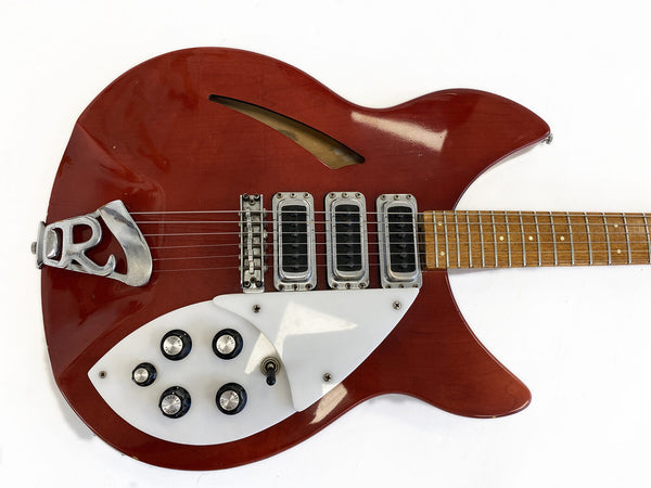 Vintage red semi-hollow electric guitar with three pickups, white pickguard, and multiple control knobs on a natural wood neck.