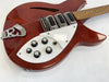 Vintage red electric guitar with white pickguard and multiple tone and volume knobs on white background