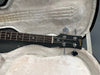 Close-up of Gibson SG bass guitar headstock and fretboard inside plush lined guitar case