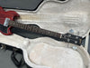 Gibson SG electric bass guitar with red finish resting in white plush interior hard case showing headstock and fretboard details