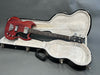 Gibson SG bass guitar with cherry red finish inside plush-lined black hardshell case on grey background