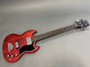 Gibson SG style electric bass guitar with cherry red finish, black pickguard, and chrome hardware on grey background