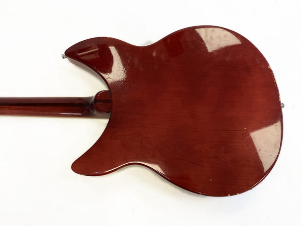 Back of vintage cherry red electric guitar body with visible wear and scratches isolated on white background