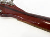 Close-up of glossy mahogany guitar neck with metal tuning pegs on white background