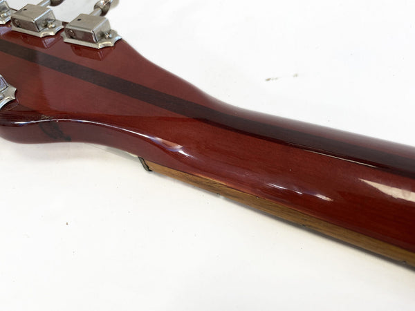 Close-up of glossy mahogany guitar neck with metal tuning pegs on white background
