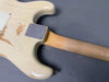 Vintage cream electric guitar body with worn finish and maple neck on grey background, showing metal neck plate with screws