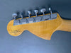 Back of Fender Custom Shop guitar headstock with six chrome tuning pegs on natural wood finish against gray background