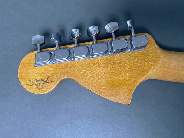Back of Fender Custom Shop guitar headstock with six chrome tuning pegs on natural wood finish against gray background