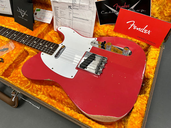 1962 Fender Telecaster electric guitar in fiesta red with white pickguard, displayed in open case with orange plush interior, Fender owner's manual, custom care booklet, and guitar certificate