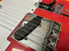 Close-up of red electric guitar bridge and pickup with Fender engraving and chrome control knob