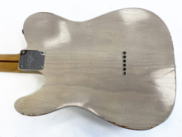 Back of vintage Fender Telecaster guitar body showing worn silver finish, string ferrules, and neck plate with Fender Custom Shop logo.