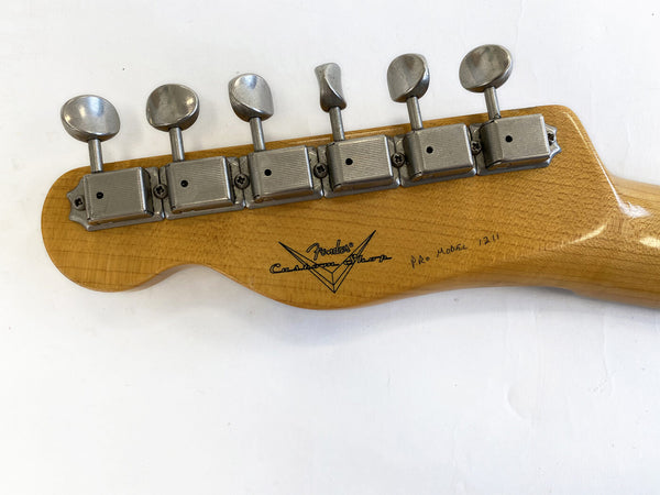 Close-up of Fender Custom Shop guitar headstock with six vintage tuning machines and serial number handwritten on maple wood neck
