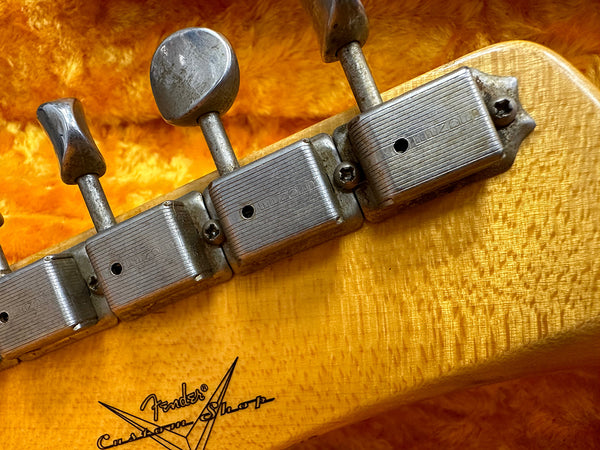 Close-up of vintage Fender Custom Shop electric guitar headstock with aged tuning pegs and flame maple wood finish
