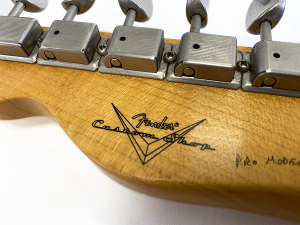 Close-up of Fender Custom Shop Pro Model vintage style tuning machines on maple guitar headstock with Fender Custom Shop logo