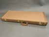 Closed brown textured hard guitar case with leather handle and gold hardware locks on gray background