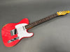 Vintage red Fender Telecaster electric guitar with white pickguard and rosewood fretboard on gray background