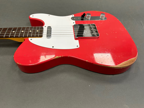 Red electric guitar body with white pickguard and visible wear on edges, featuring chrome bridge and two control knobs on gray background