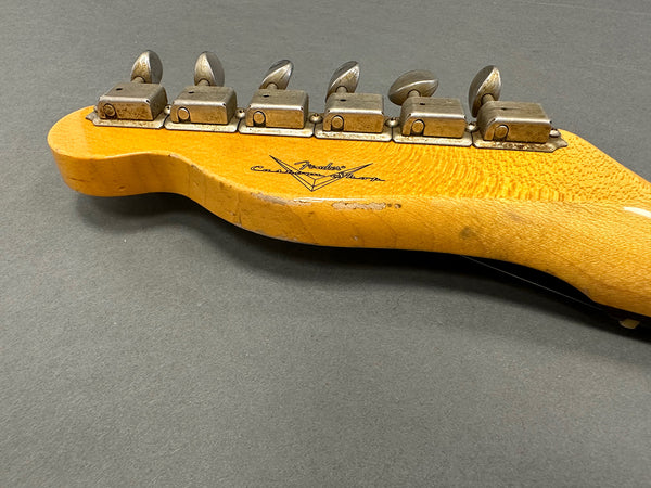 Vintage Fender Custom Shop guitar neck with six vintage tuning pegs on gray background