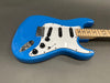 Blue electric guitar with white pickguard, three single-coil pickups, and maple neck on gray background